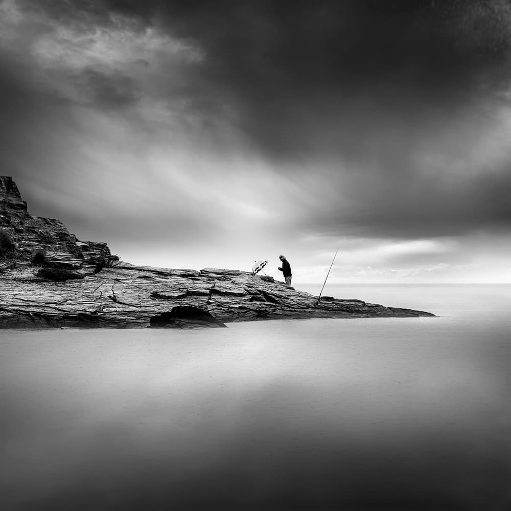 Lone Fisherman Rocky Coast by George Digalakis — canvas wall art
