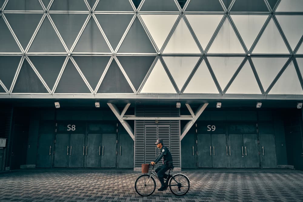 Cyclist Past Geometric Facade by MingLun Tsai (蔡明倫) — canvas wall art