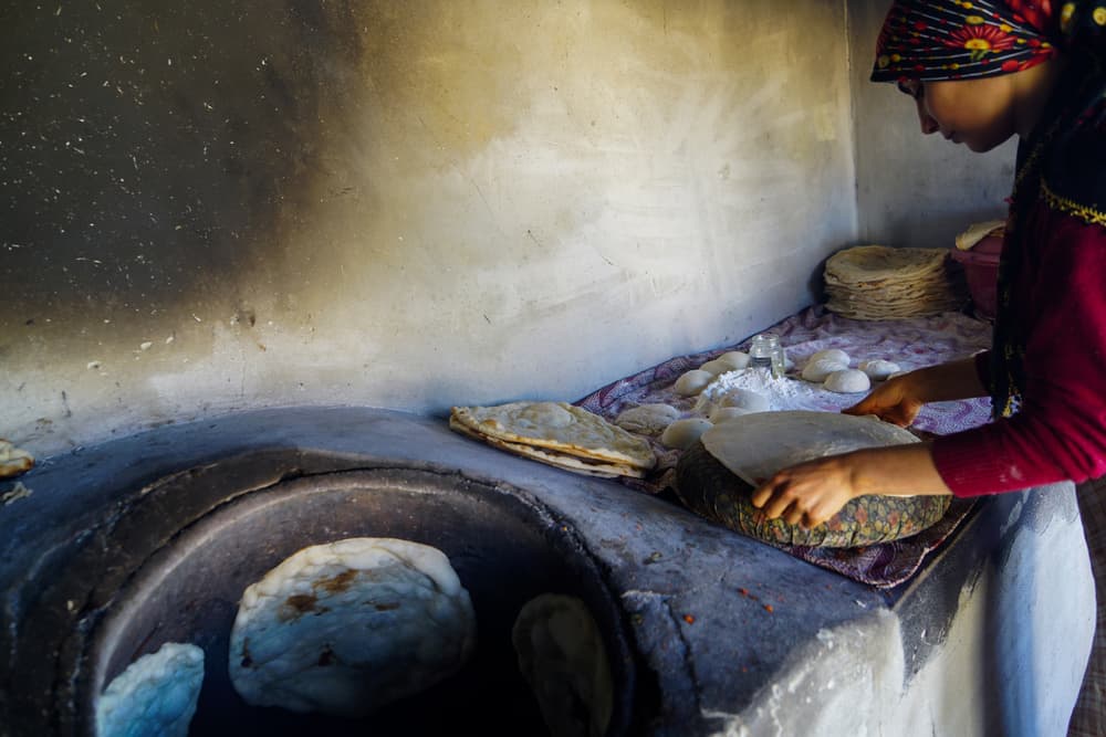 Woman Bakes Tandoor Bread by Fatma GÖKMEN — canvas wall art