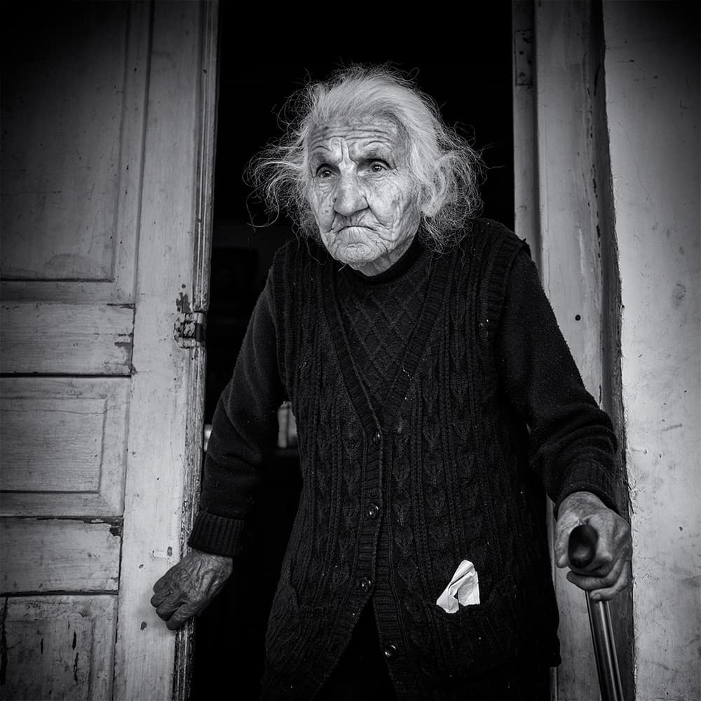 Elderly Woman Doorway by Marcel Rebro — canvas wall art