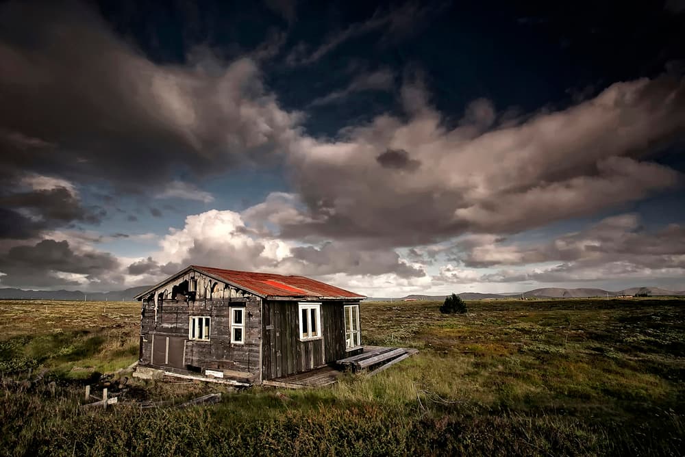 Rustic Cabin Under Stormy Sky by Þorsteinn H. Ingibergsson — canvas wall art