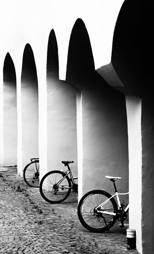Shadowed Arches and Bicycles by Raffaele Corte — canvas wall art