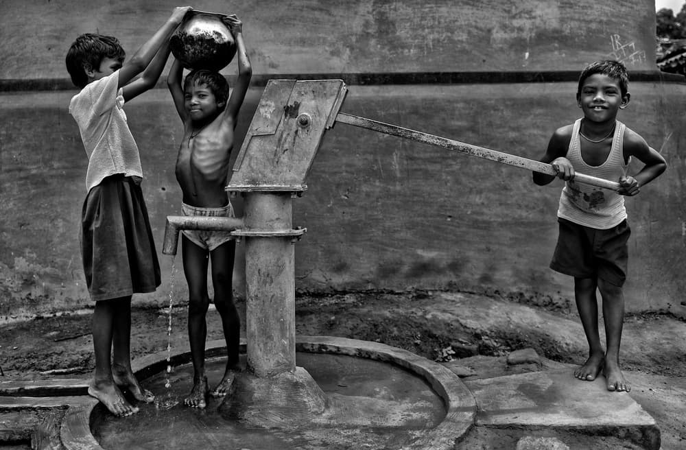 Children Pumping Water by Avishek Das — canvas wall art