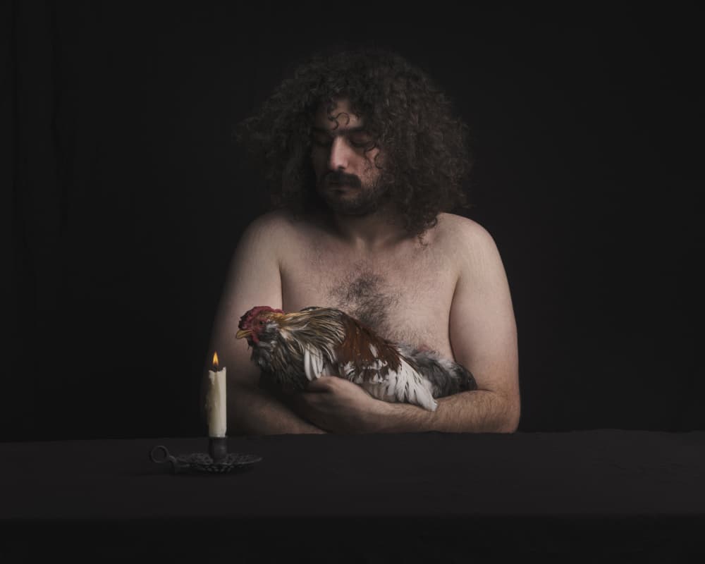 Pensive Man Holding Rooster by Hooman Sedaghi — canvas wall art