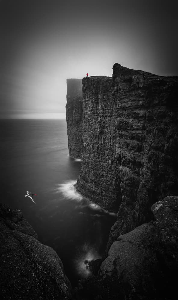 Red Coat Cliff Edge by Lydia Jacobs — canvas wall art