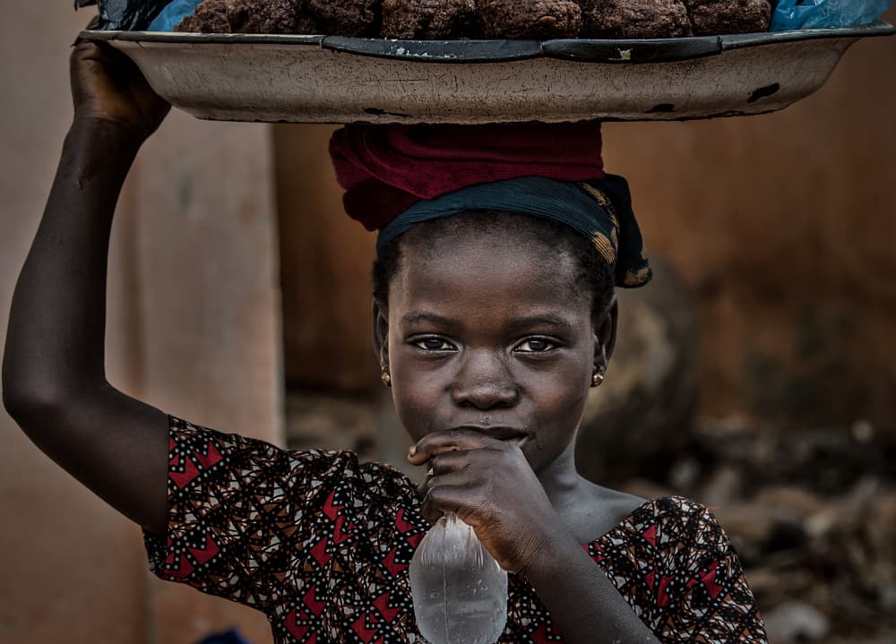 African Vendor Girl by Joxe Inazio Kuesta Garmendia — canvas wall art