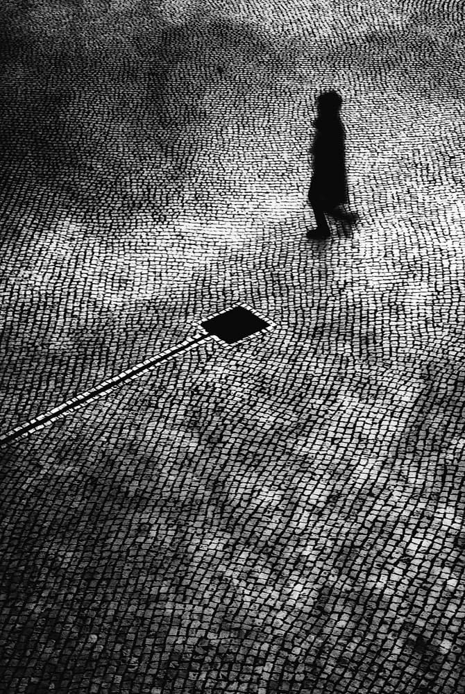 Lone Figure on Cobblestone by Paulo Abrantes — canvas wall art
