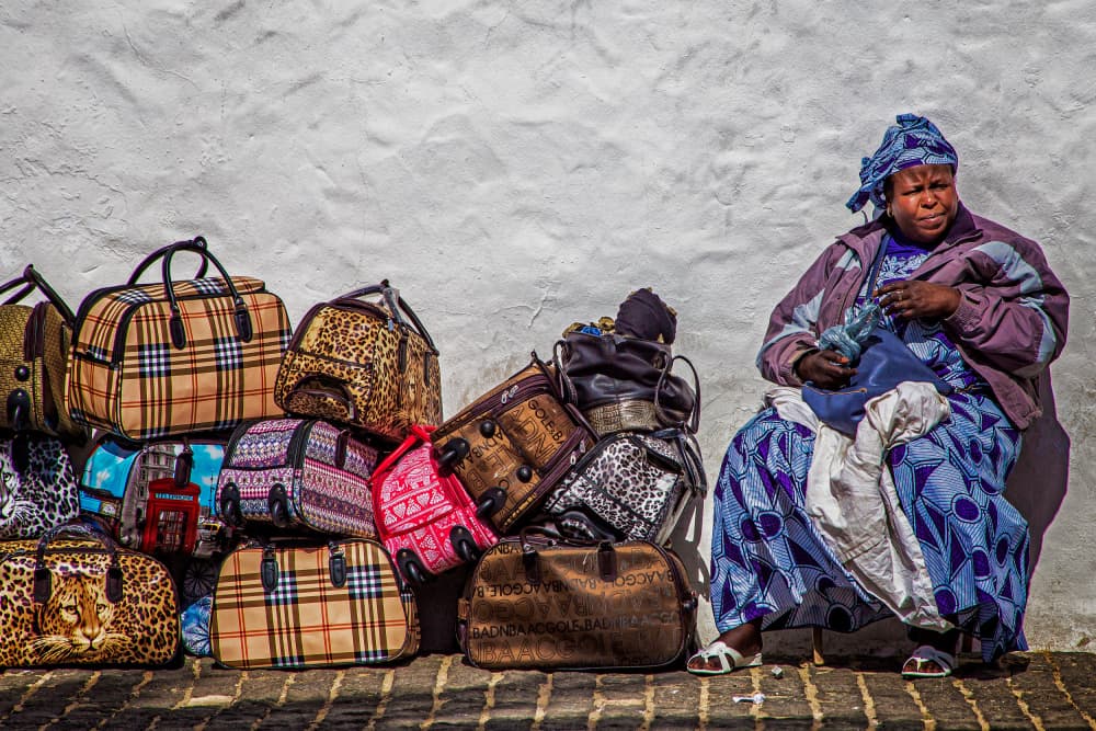 African Vendor and Bags by Eric Mattheyses — canvas wall art