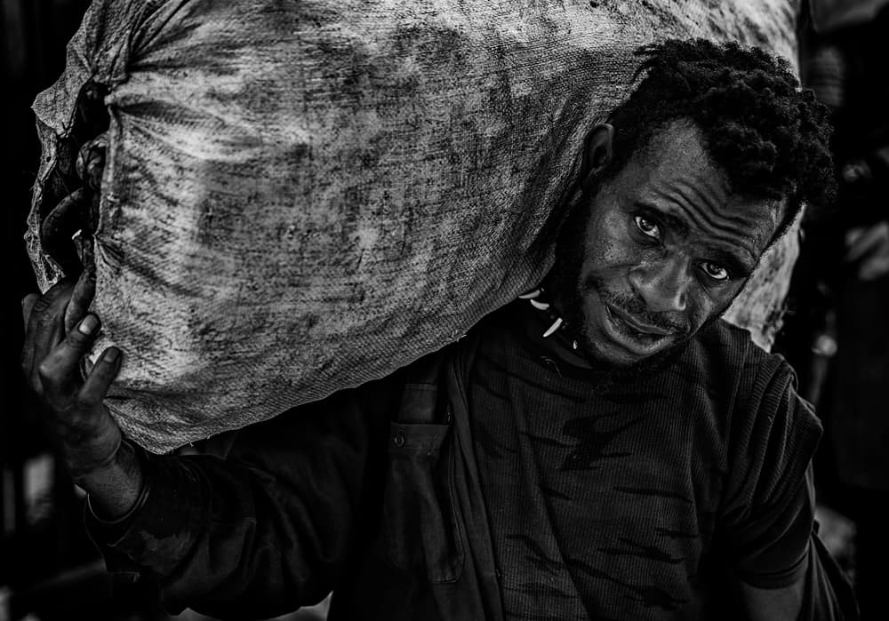 Man Carrying Heavy Bag by Joxe Inazio Kuesta Garmendia — canvas wall art