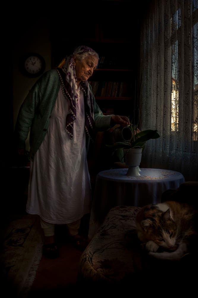 Senior Woman Watering Plant by Ramiz Sahin — canvas wall art