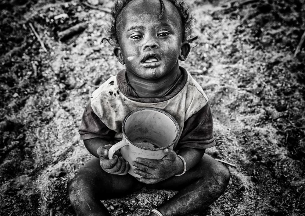 Child Holding Empty Mug by Joxe Inazio Kuesta Garmendia — canvas wall art