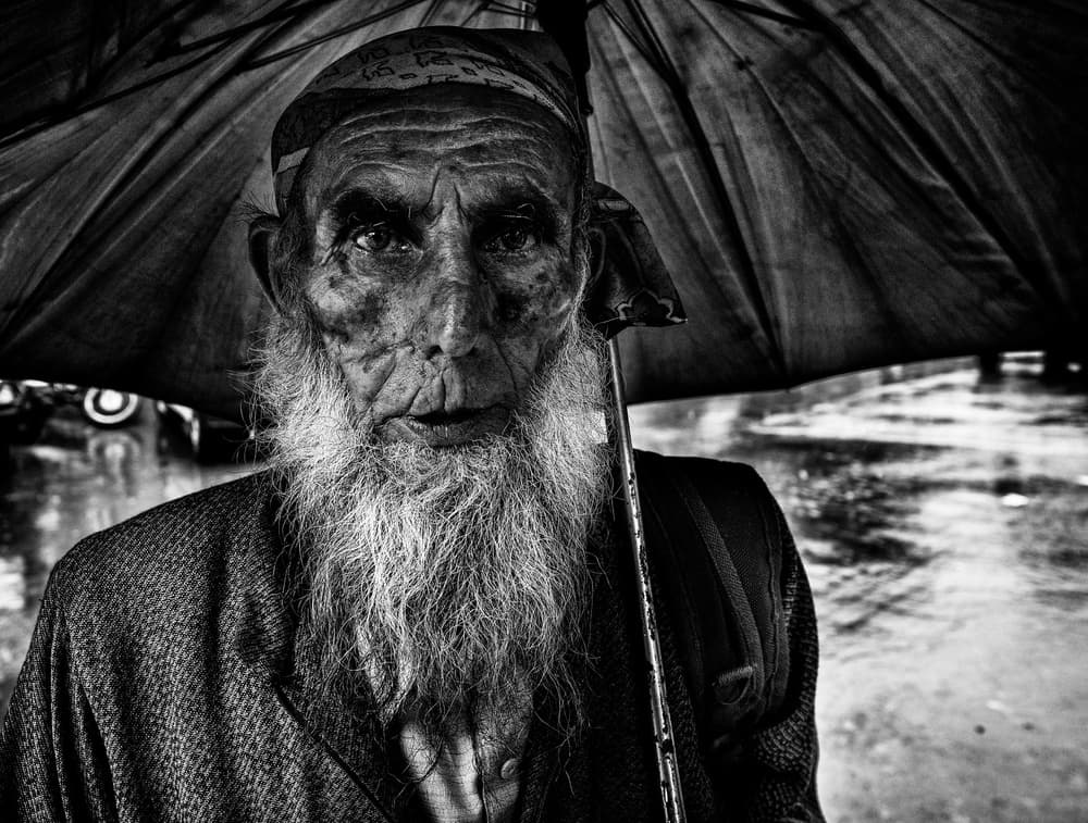Old Man Under Umbrella by Joxe Inazio Kuesta Garmendia — canvas wall art
