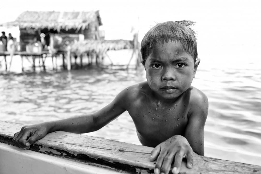 Boy In Water Village by Kieron Long — canvas wall art