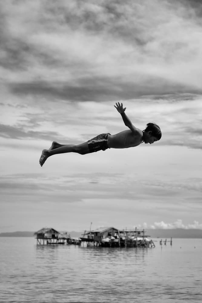Flying Boy Over Water by Kieron Long — canvas wall art