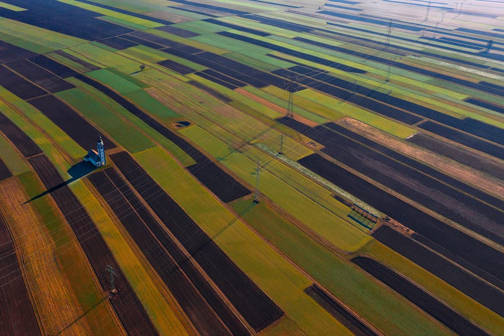 Church Among Striped Fields by Jure Kravanja — canvas wall art