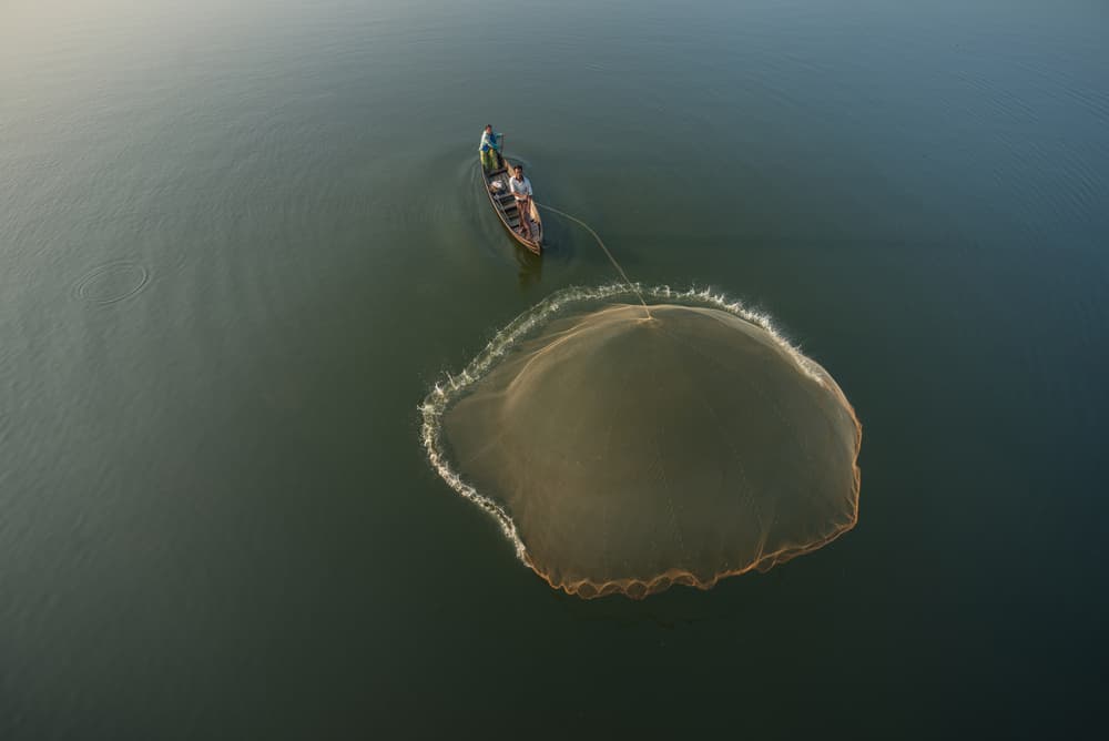 Fisherman Casting Golden Net by Sarawut Intarob — canvas wall art