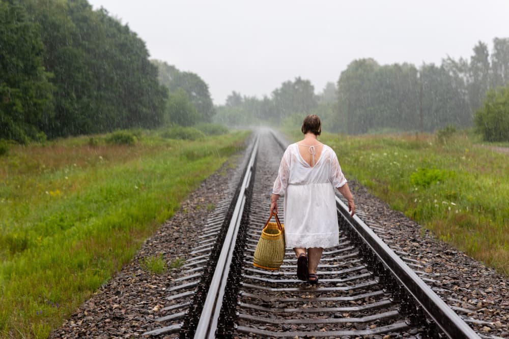 Woman On Rainy Tracks by Normunds Kaprano — canvas wall art