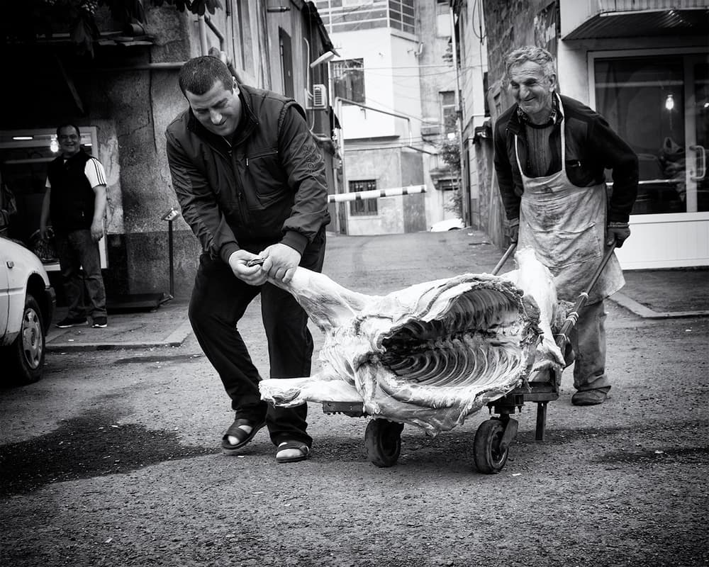 Street Butchers Moving Meat by Marcel Rebro — canvas wall art