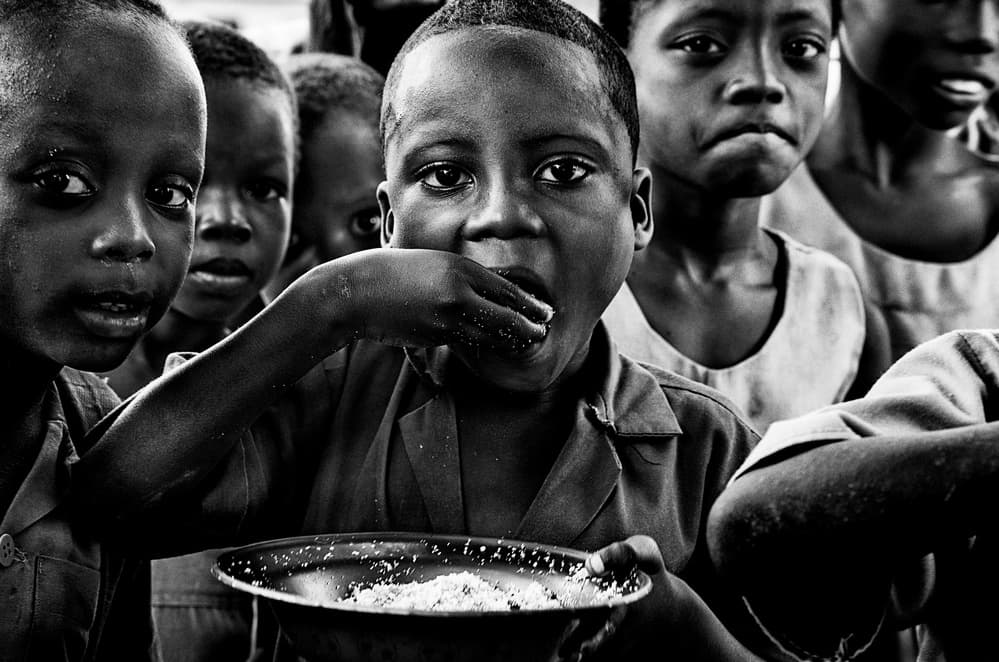 African Children Eating Meal by Joxe Inazio Kuesta Garmendia — canvas wall art