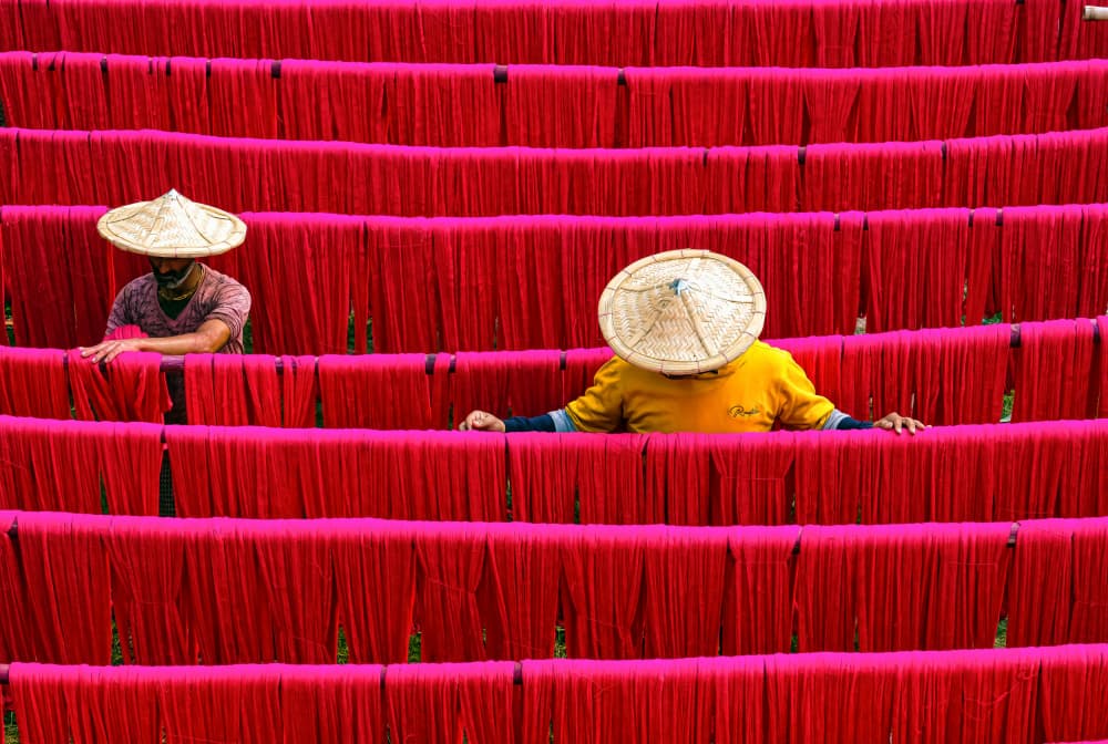 Vibrant Red Textile Drying by Ajit Kumar Majhi — canvas wall art