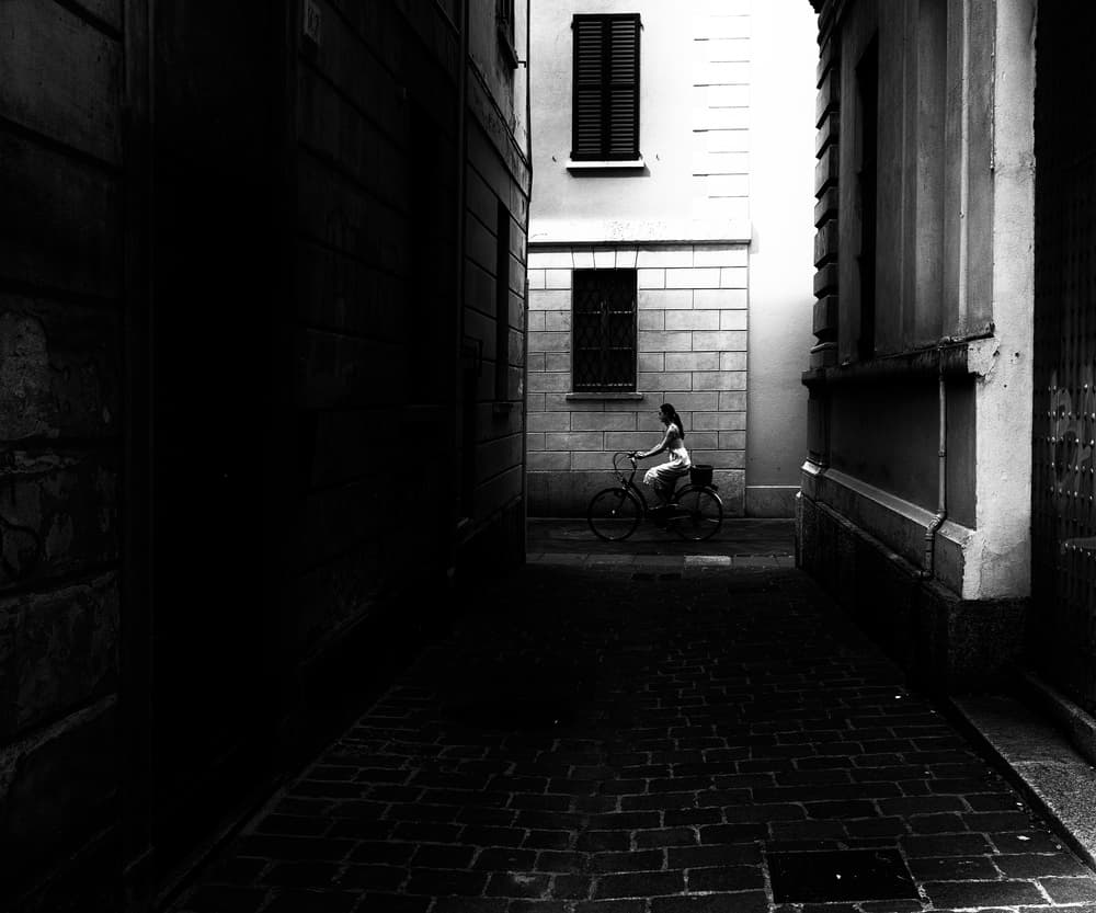 Woman Cycling Alley by Julien Oncete — canvas wall art