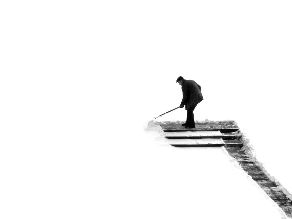 Man Clearing Snowy Steps by Wojciech Pokora — canvas wall art
