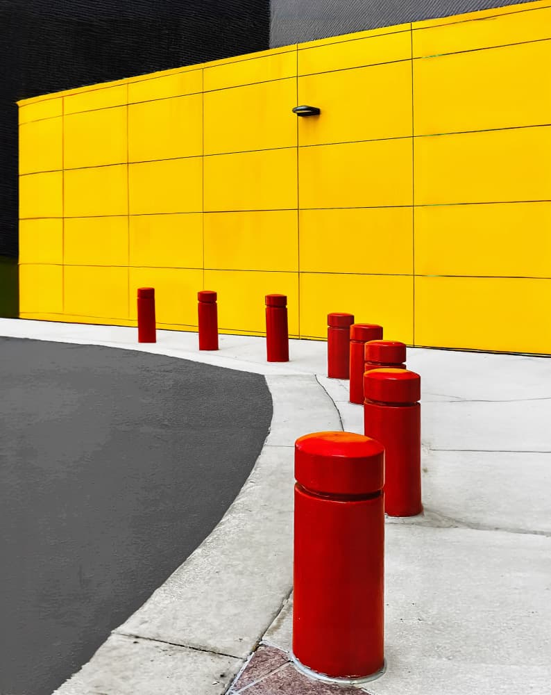 Vibrant Yellow Wall Red Bollards by Arnon Orbach — canvas wall art