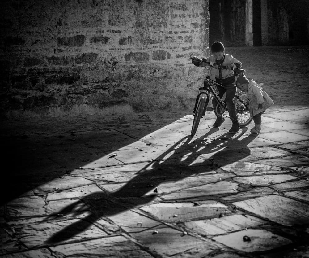Children Pushing Bike Shadows by John Yuk Kong Chung — canvas wall art