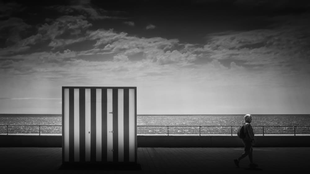Monochrome Beach Hut Stroll by Rolf Endermann — canvas wall art