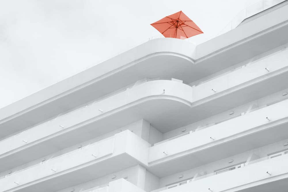 White Building Orange Umbrella by Rolf Endermann — canvas wall art