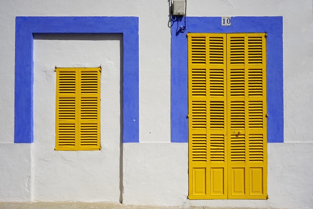 Blue Frame Yellow Shutters by Norbert Maier — canvas wall art
