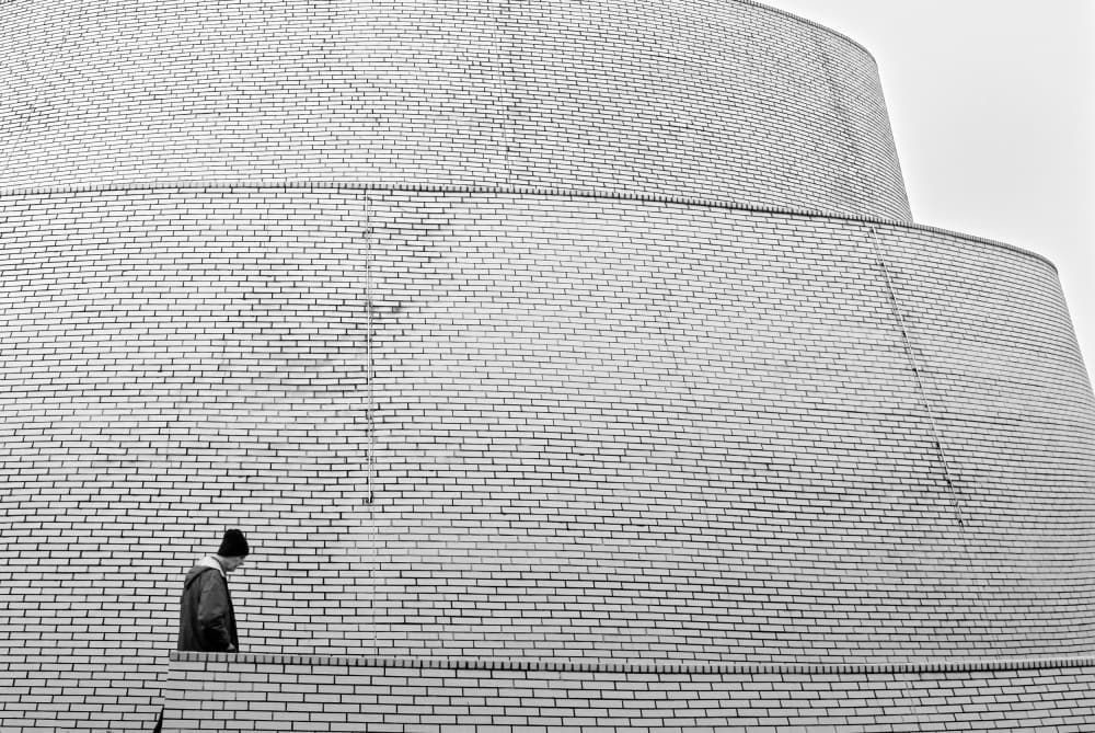 Man Walking Brick Wall by Andreas Timar — canvas wall art
