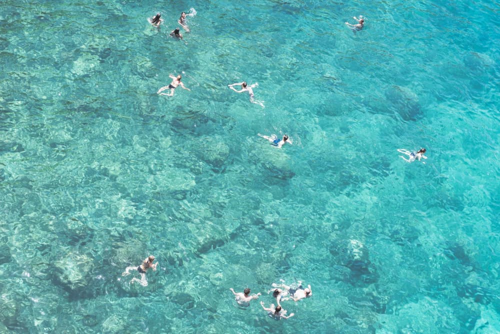 Swimmers in Turquoise Water by Photolovers — canvas wall art