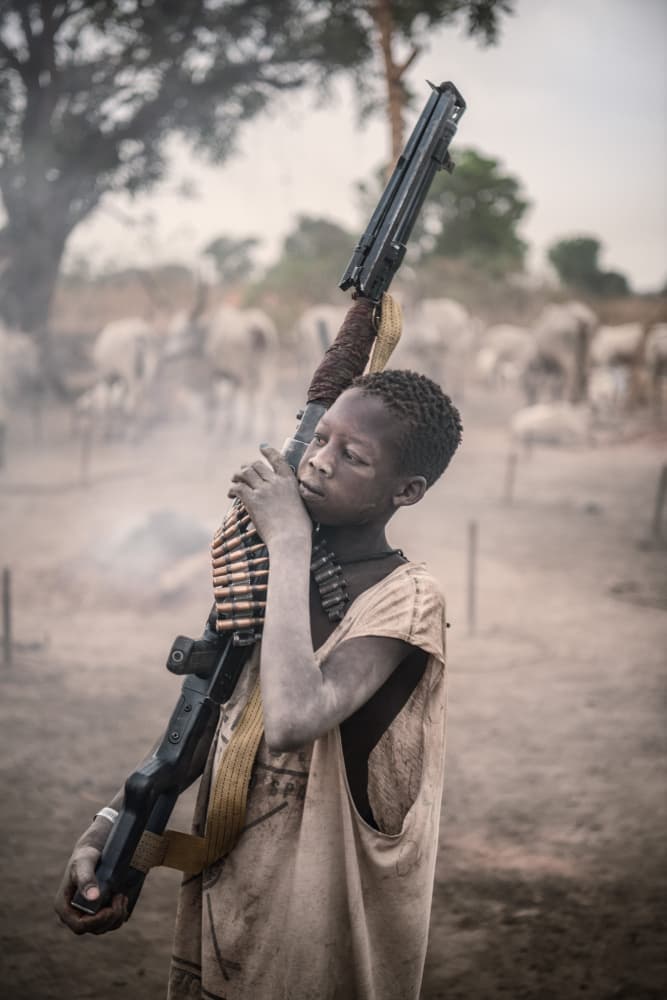 African Boy Carrying Weapon by Trevor Cole — canvas wall art