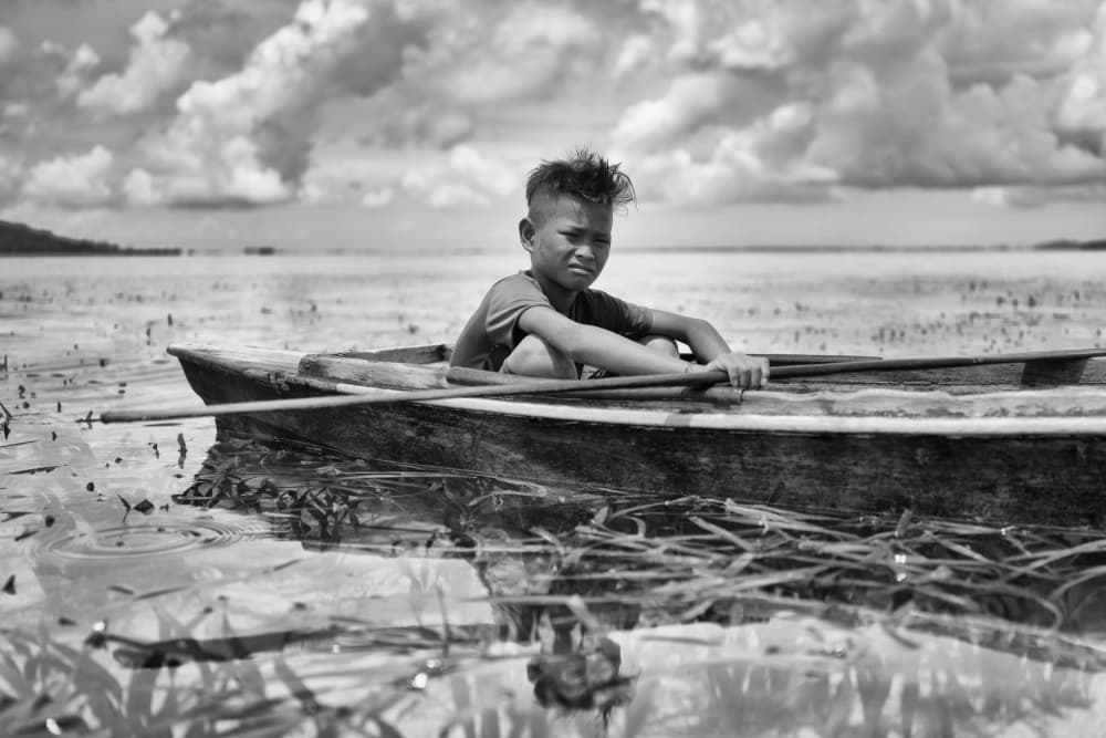 Pensive Boy in Boat by Kieron Long — canvas wall art