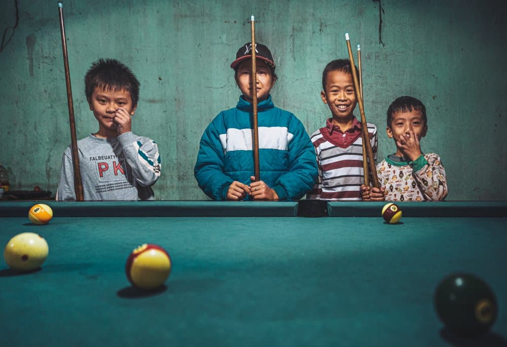 Smiling Boys Play Pool by Marco Tagliarino — canvas wall art