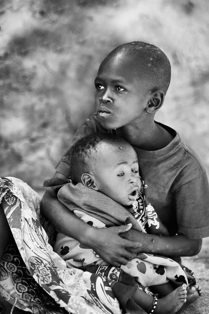 African Brothers Hug by Phillip Chang — canvas wall art